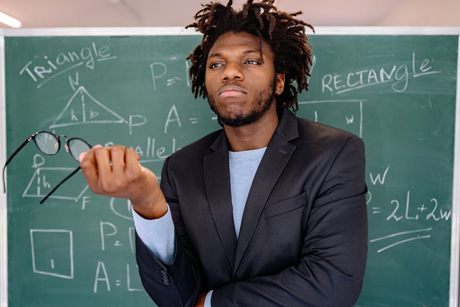 Docente di matematica con occhiali e lavagna: un futuro di qualifiche con istruzione e formazione professionale