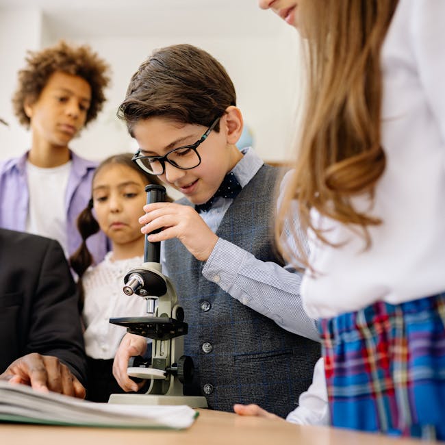 Bambini che usano un microscopio in classe, esempio di didattica innovativa e crescita della competenza scientifica a scuola