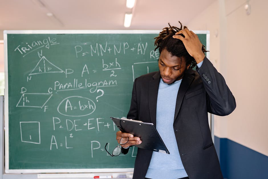 Insegnante di matematica per Metodo Bortolato con lavagna piena di formule geometriche, espressione pensierosa e appunti in mano.