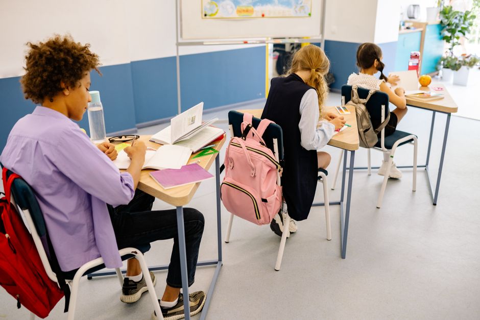 Bambini in classe studiano ai banchi con zaini colorati, in vista dell'apertura delle scuole in Piemonte dal 31 agosto.