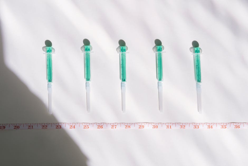 Siringhe mediche con liquido verde e metro: misurazione e controllo dei livelli di mg/dl per la salute e il benessere.