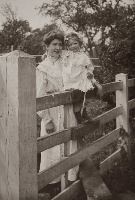 Madre e figlia su staccionata in bianco e nero, evocazione di ricordi d'infanzia legati alla scrittura con penna stilografica d'epoca.