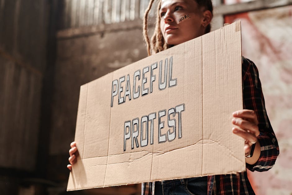 Giovane manifestante con cartello Peaceful Protest per la giustizia sociale e un futuro equo e inclusivo per tutti.