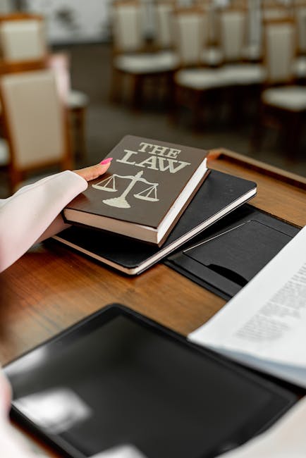 Libro di legge con bilancia della giustizia, simbolo di normative per studenti con alto potenziale e piani di studio personalizzati