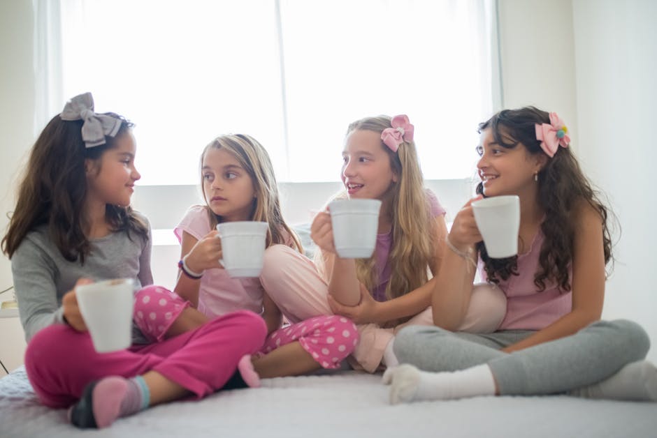 Quattro amiche in pigiama bevono da tazze bianche, conversazione rilassata, forse calcolando conversioni libbre in kg per ricette.
