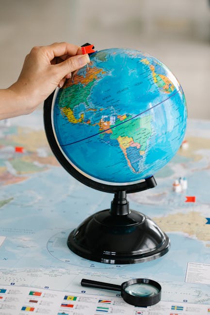 Globo geografico con spilla rossa, metafora di scoperta e conoscenza, ideale per articolo sui vantaggi dei libri elettronici.