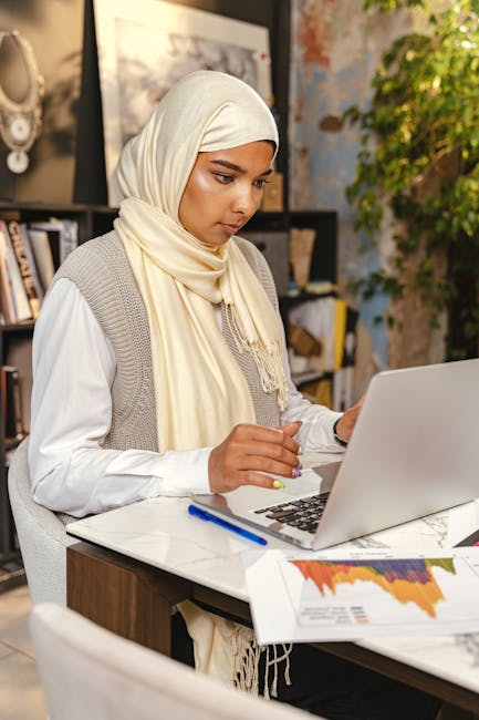 Studentessa con hijab analizza dati socio-educativi al computer, divario Nord-Sud nel Rapporto Openpolis, istruzione e disuguaglianze