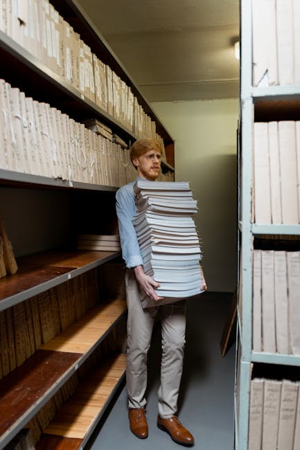 Studente UniCal trasporta documenti nell'archivio del Dipartimento di Scienze Politiche e Sociali, evidenziando l'accesso alle risorse