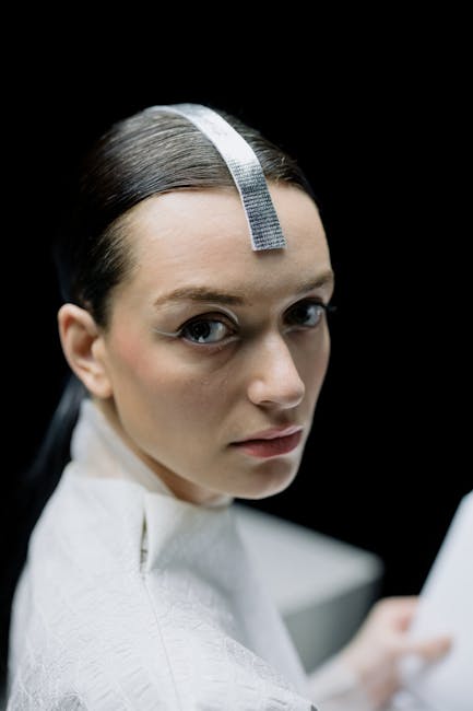 Ballerina futuristica con accessorio metallico, espressione intensa, innovazione nella danza e performance uniche