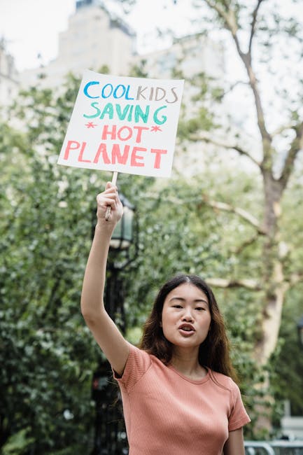 Giovane attivista con cartello Cool Kids Saving Hot Planet per attività didattiche sul riscaldamento globale e coinvolgimento nuove generazioni