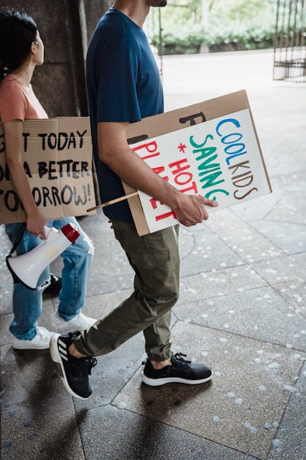 Giovani manifestanti per il clima con cartelli e megafono: un futuro sostenibile dipende dalle nostre scelte e azioni concrete.