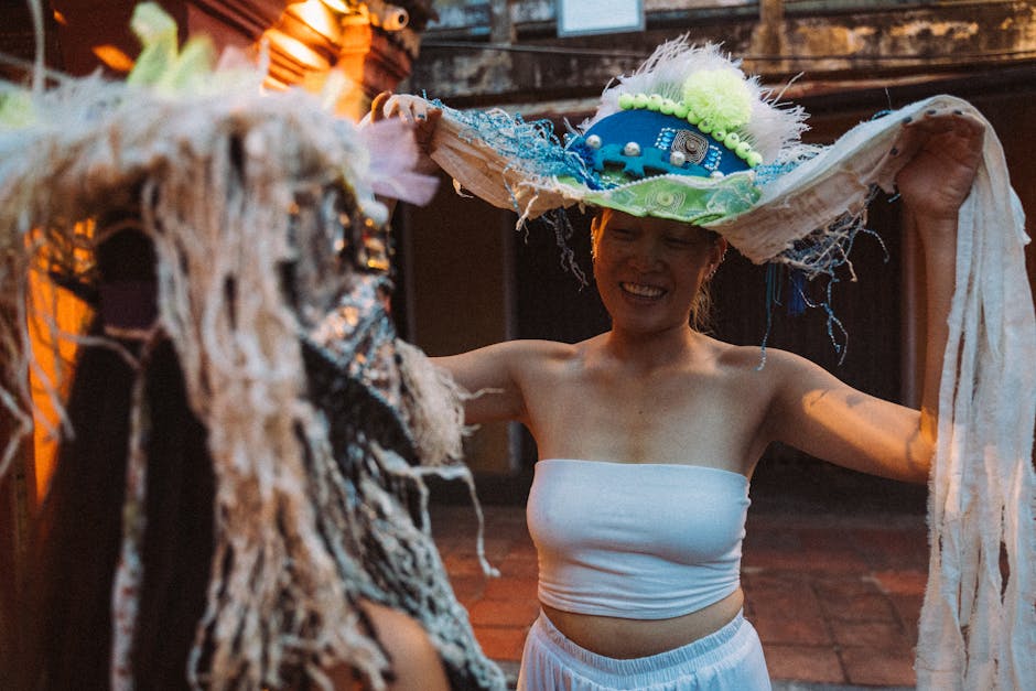 Performance artistica a La Sera Fiesolana: donna sorridente con cappello decorato interagisce con figura mascherata