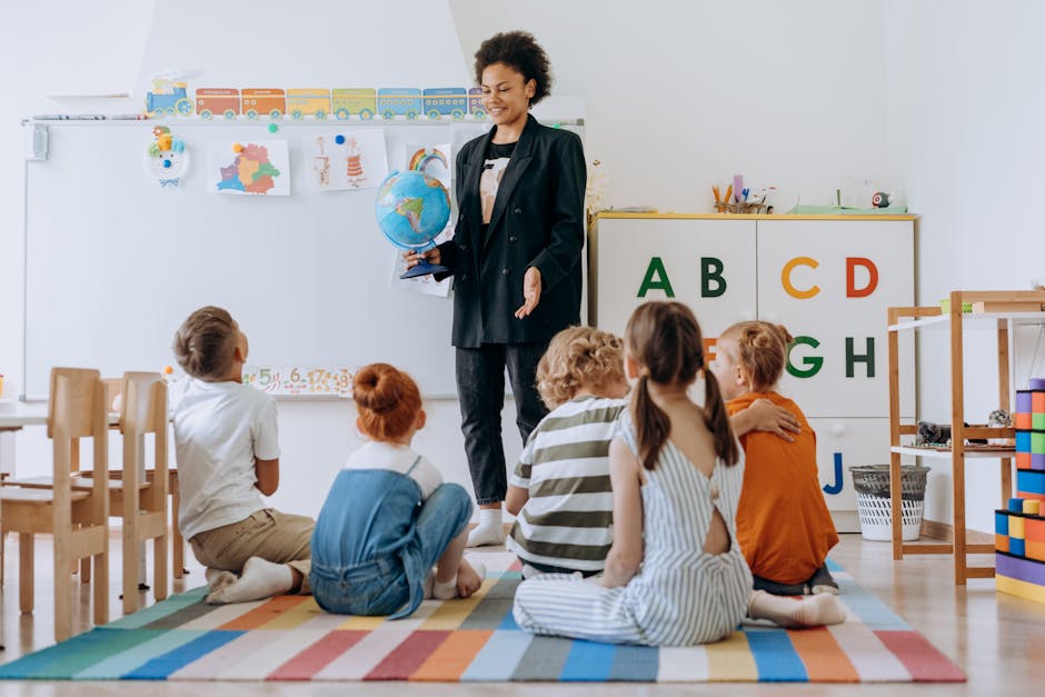 Insegnante di scuola primaria con globo che spiega ai bambini seduti sul tappeto, pensioni scuola e lavoratori precoci