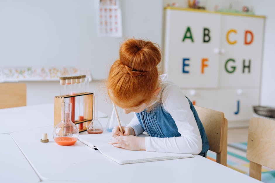 Bambina rossa scrive su quaderno in classe con provette e alunnno sullo sfondo. Progetti scolastici di eccellenza per le Buone Pratiche di formazione.