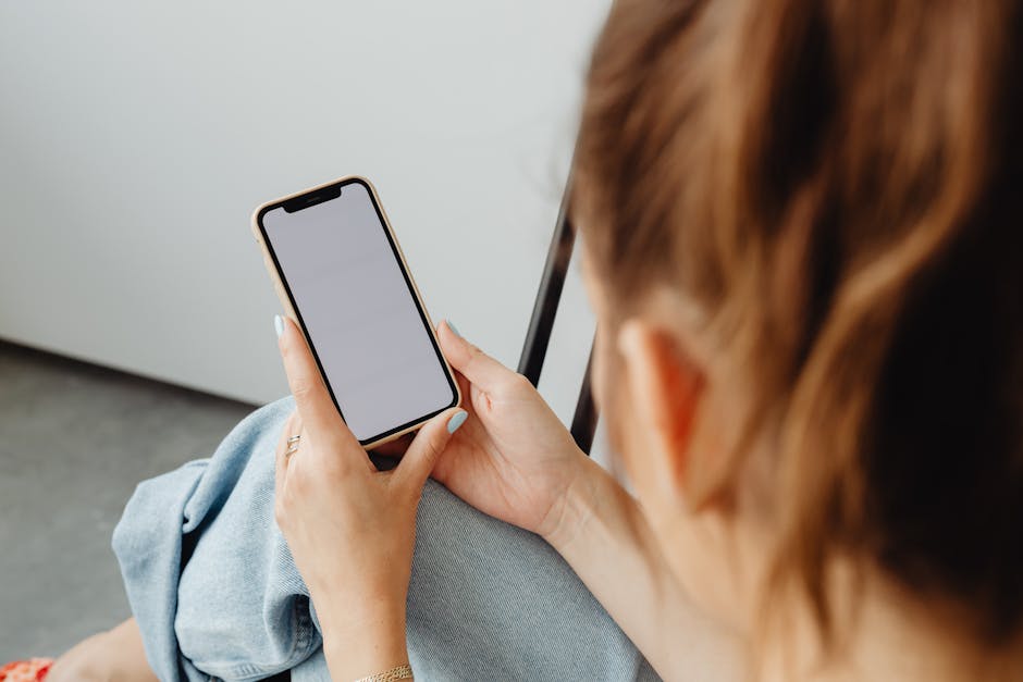 Donna consulta registro elettronico su smartphone, normativa e divieto pubblicità, gestione digitale dati aziendali e conformità legale.