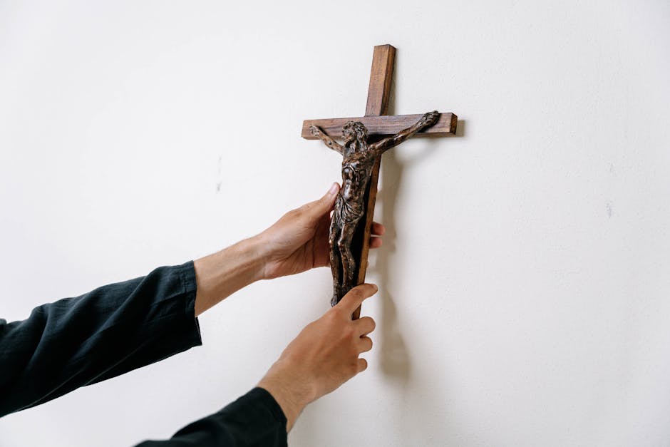 Allegoria della fede: mani che appendono crocifisso in legno, simbolo di sacrificio e redenzione, arte e significato nascosto.