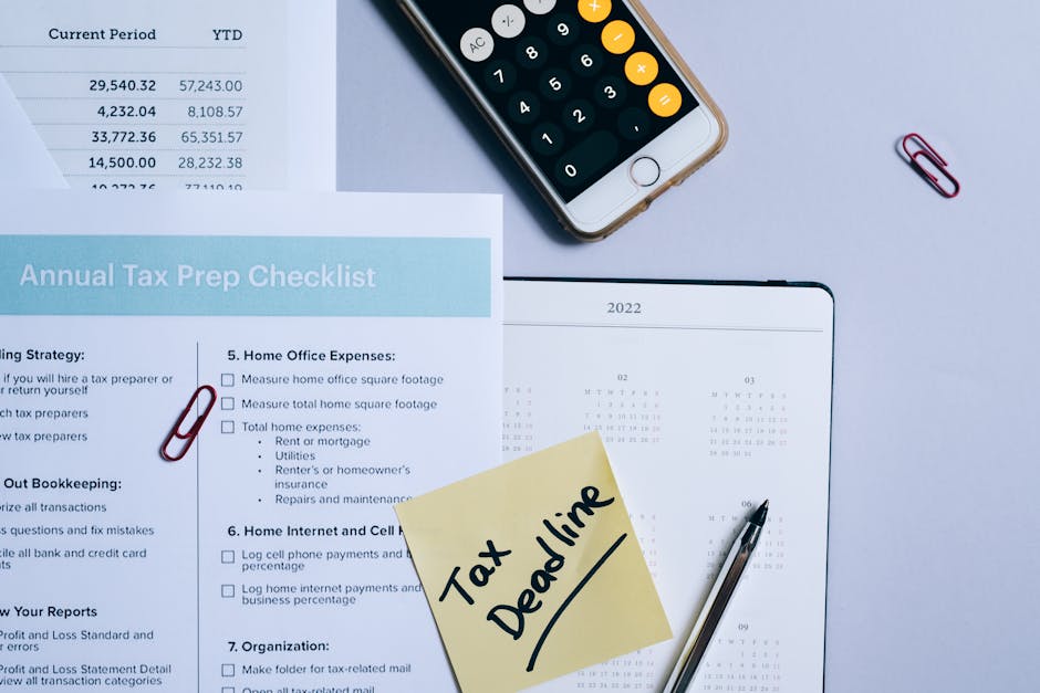 Scadenza tasse anno bisestile: promemoria su calendario 2022 con checklist, calcolatrice e post-it promemoria per la dichiarazione dei redditi.