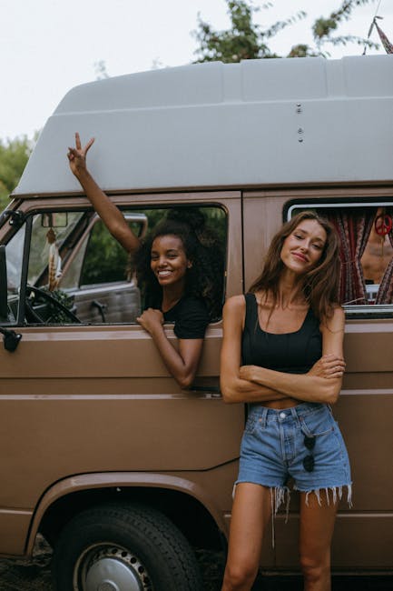 Due amiche sorridenti in camper: idee per un Halloween all'insegna dell'avventura e del divertimento con gli amici.