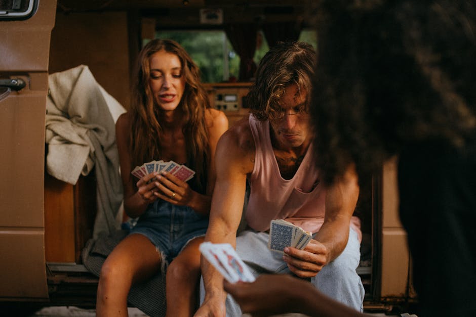 Amici che giocano a carte in un furgone durante un'attività musicale divertente e condivisa, ideale per creare ricordi indimenticabili.