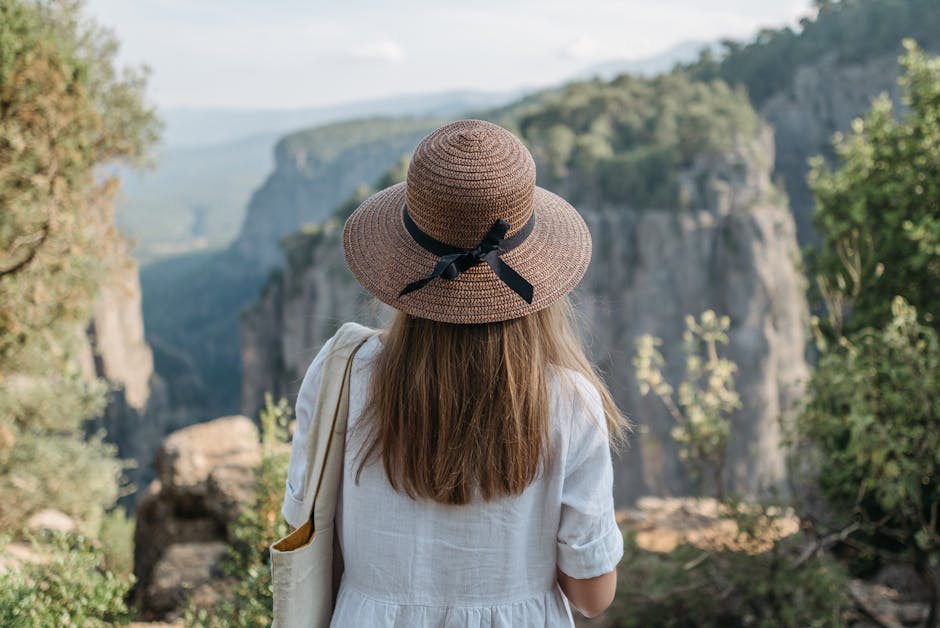 Donna con cappello di paglia ammira il canyon: attività per celebrare la Giornata della Terra e la bellezza della natura