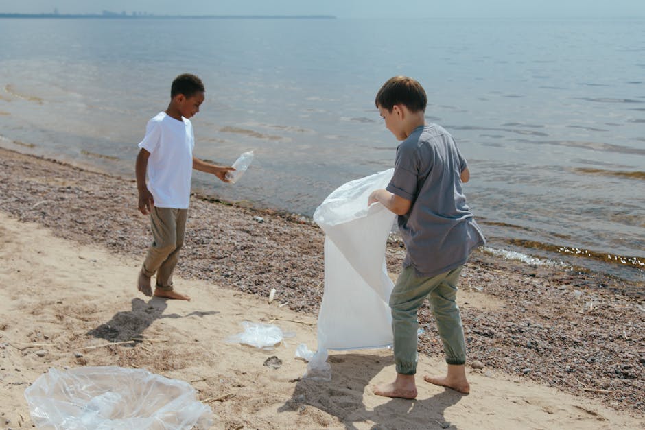Due bambini raccolgono plastica sulla spiaggia: iniziativa di economia verde per un futuro sostenibile e pulizia ambientale