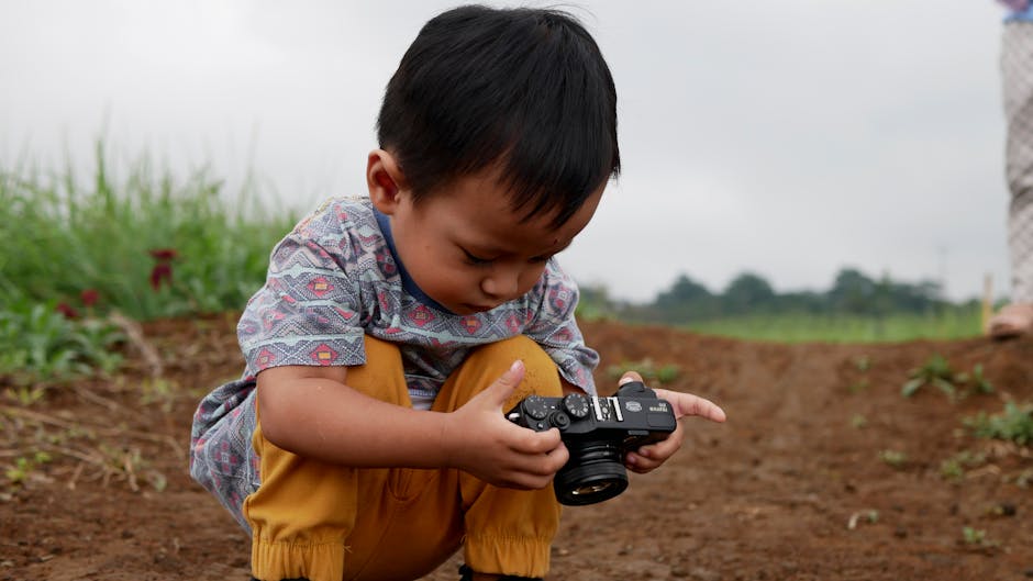 Bambino che esplora una fotocamera: metafora dell'apprendimento con l'intelligenza artificiale in ambito educativo per i più piccoli.