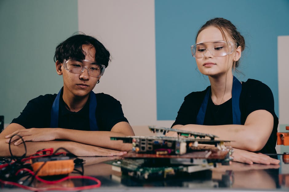 Studenti con occhiali protettivi impegnati nell'apprendimento basato sul problema unico con circuiti elettronici e strumenti