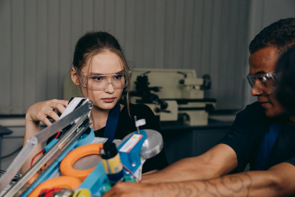 Studenti con occhiali protettivi lavorano a progetto di robotica, esempio di applicazione dell'IA nell'istruzione e apprendimento pratico.