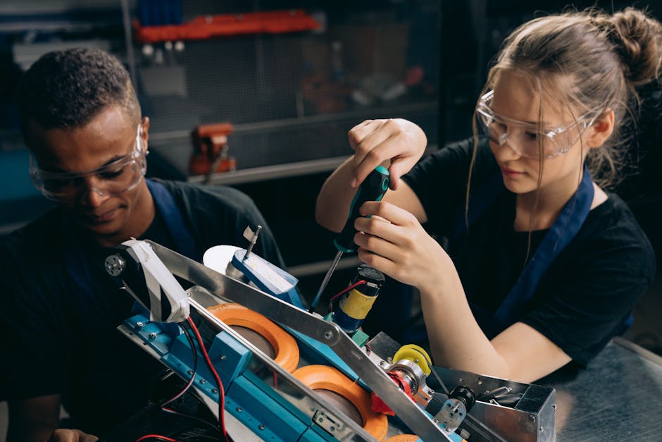 Studenti che collaborano a un progetto di robotica con intelligenza artificiale, indossando occhiali protettivi, scuola e futuro innovativo.