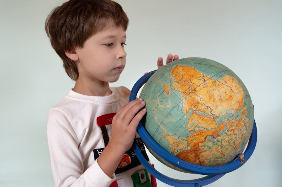 Bambino osserva un mappamondo: risorsa didattica per la scuola primaria, esplorazione geografica e apprendimento interattivo con schede didattiche.