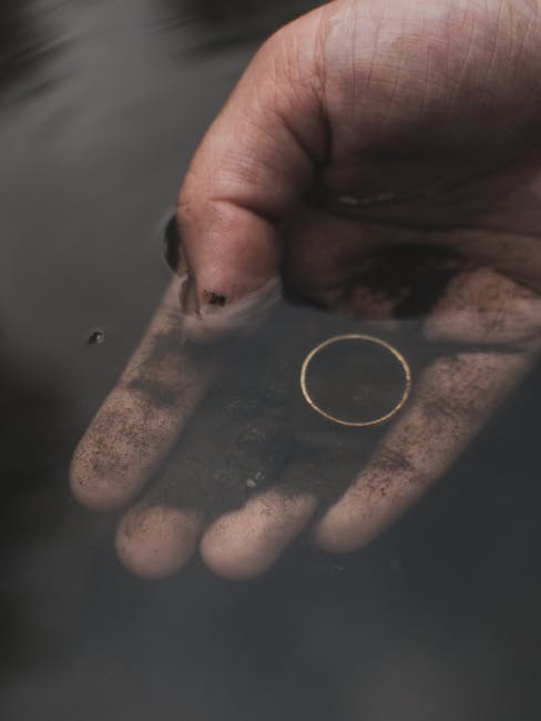 Mano sporca nell'acqua con anello dorato: metafora dell'unicità e della scoperta nel Quinto Postulato di Euclide