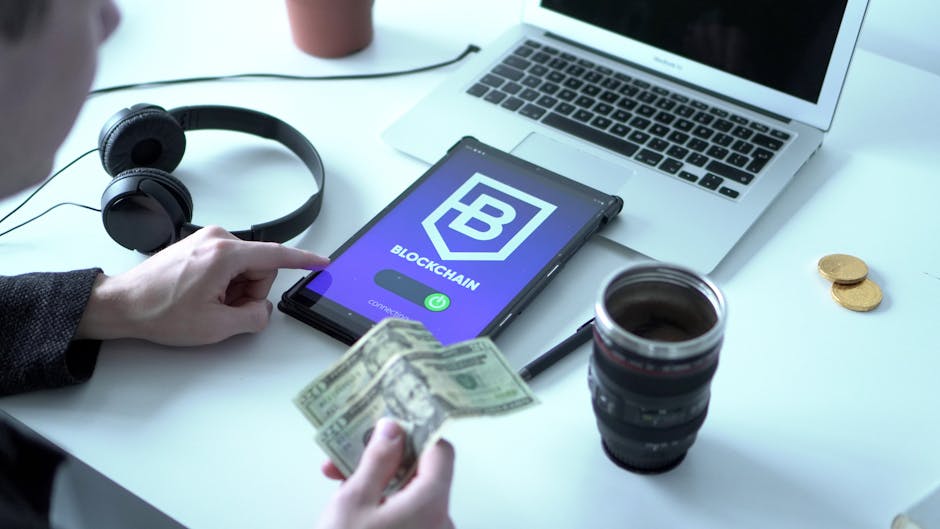 Economia digitale: uomo usa tablet con blockchain, banconote e laptop. Educazione finanziaria e futuro digitale per tutti.