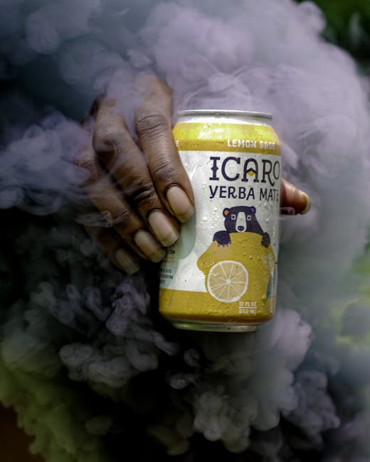 Mano che tiene lattina di Yerba Mate Icaro Lemon Sage avvolta nel fumo, simbolo di energia e focus per una pianificazione efficace.