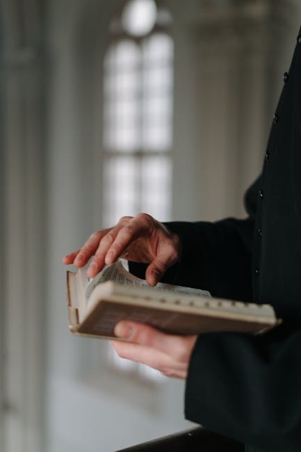 Persona che sfoglia un libro antico, simbolo della connessione tra teoria e pratica nell'educazione trasformativa.