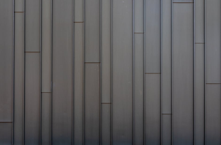 Rivestimento metallico con pannelli verticali paralleli di diverse lunghezze, esempio di design moderno e minimalista.