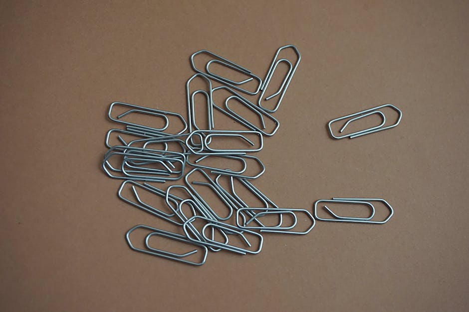 Groviglio di graffette metalliche su sfondo marrone, simbolo di burocrazia e documenti per le elezioni degli organi collegiali scolastici.