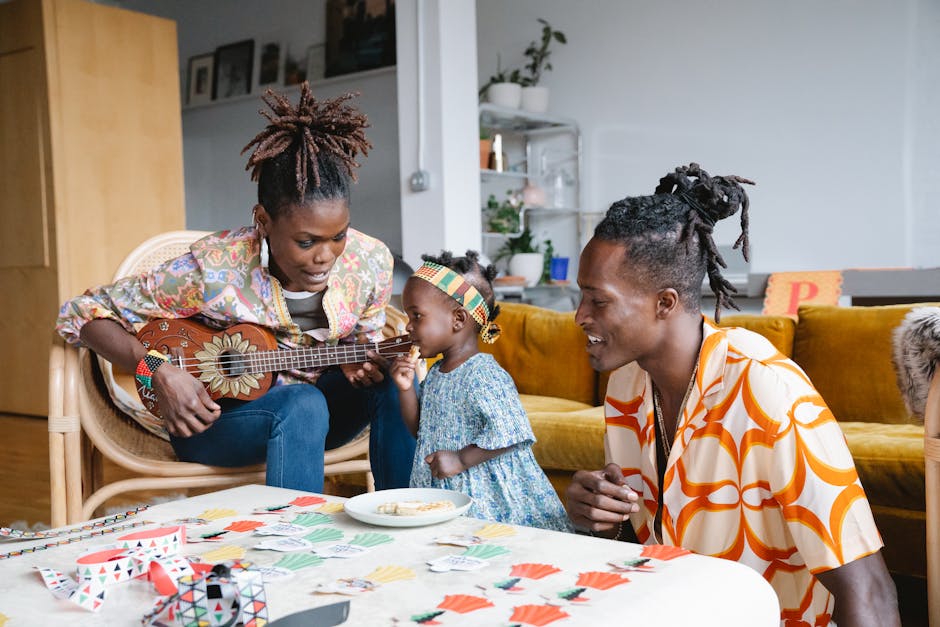 Famiglia afroamericana che suona l'ukulele e gioca a carte, promuovendo creatività e divertimento con giochi musicali per bambini.