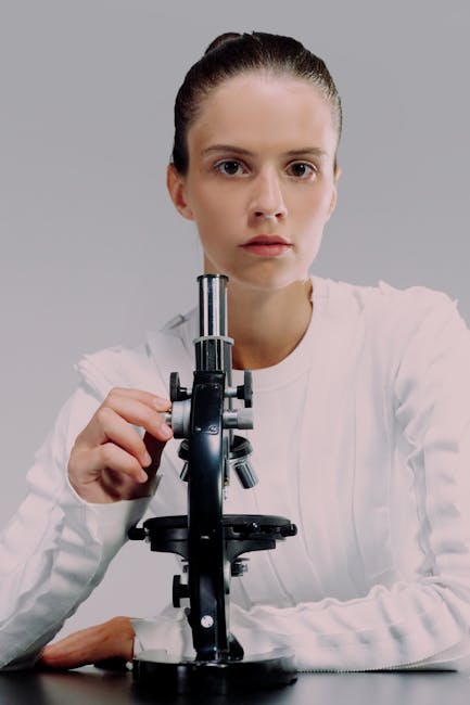 Ragazza che usa un microscopio per lo studio della fisica e ripetizioni scientifiche per migliorare le competenze