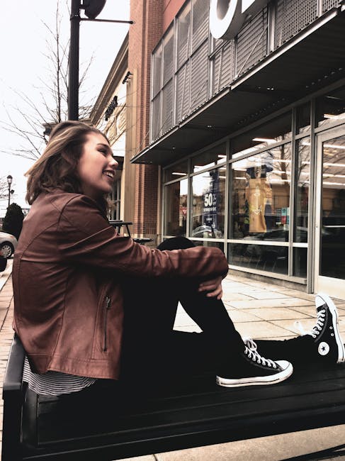 Ragazza sorridente seduta su una panchina con scarpe Converse, visualizzazione del concetto di peso e conversione da libbre a kg.