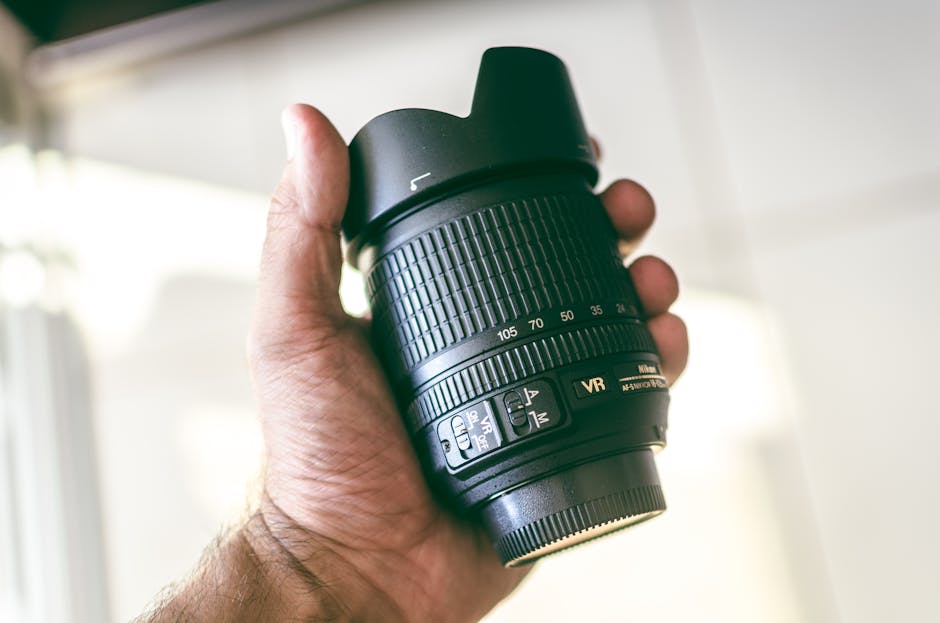 Obiettivo Nikon in mano per valutazione precisa delle prestazioni e risultati efficaci con metodi affidabili di analisi ottica.