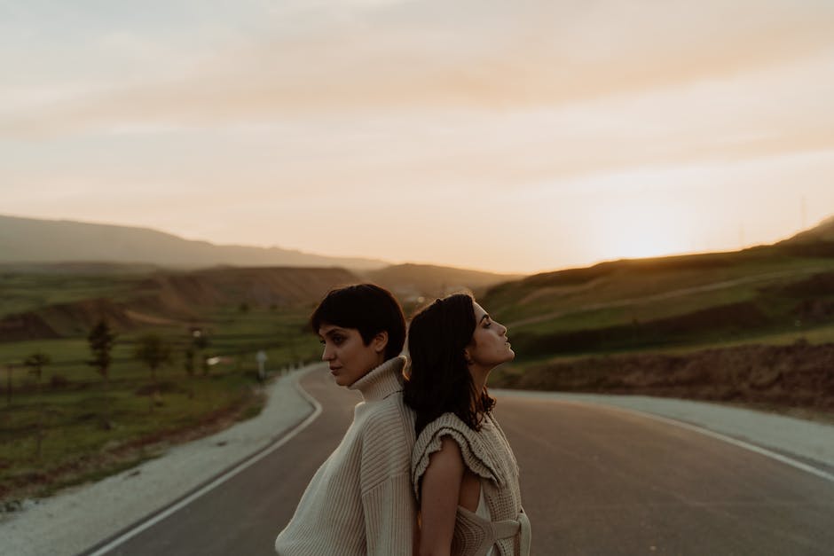 Due donne schiena contro schiena su strada al tramonto, metafora dell'armonia e dell'equilibrio come nel triangolo isoscele