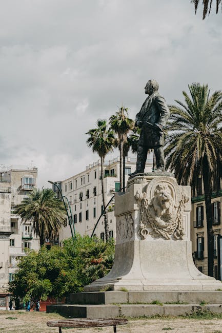 Statua di figura maschile a Napoli, simbolo del valore dell'istruzione e del riconoscimento economico dei docenti italiani.