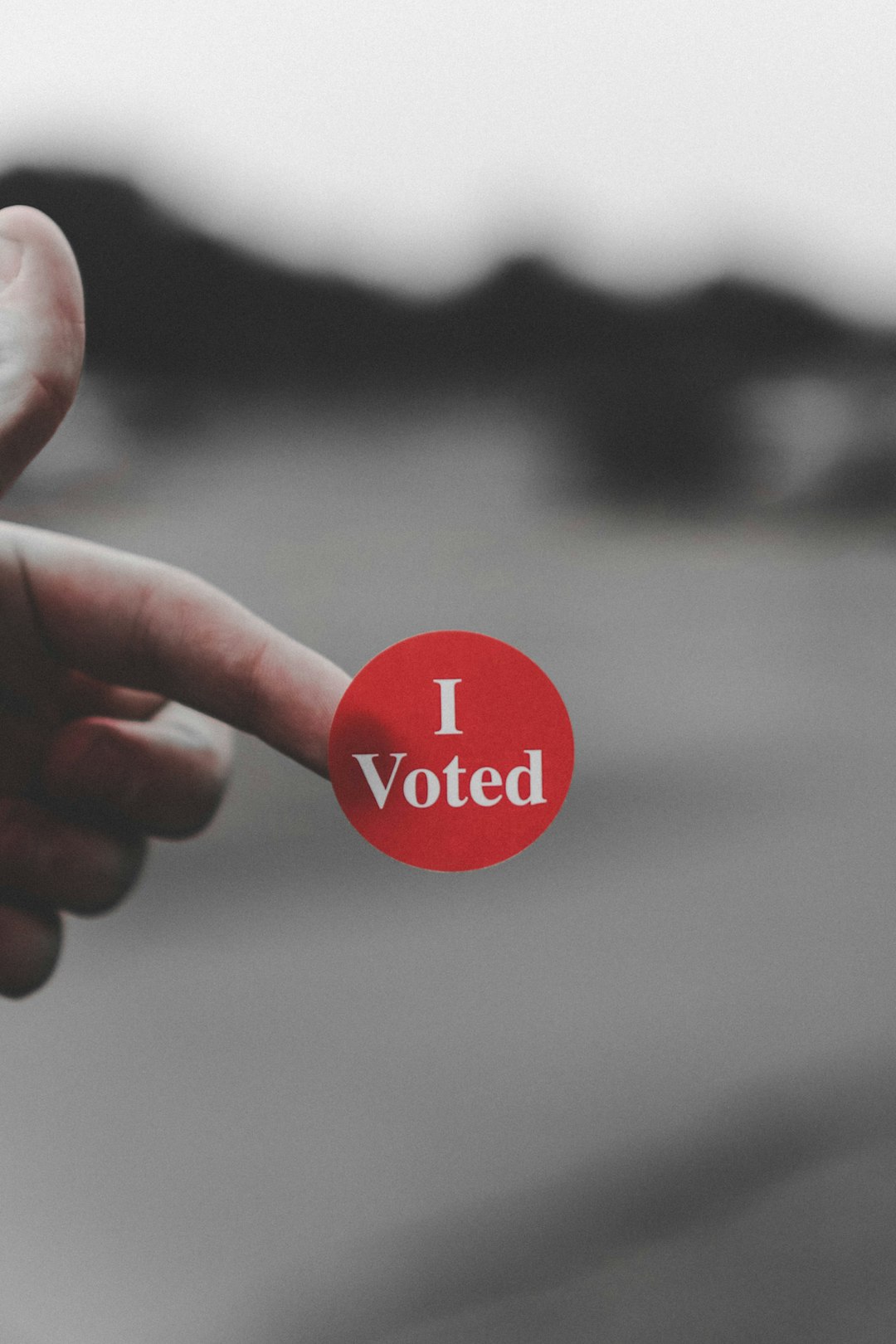 Dito con adesivo rosso con scritta I Voted, simbolo di partecipazione civica e diritto di voto