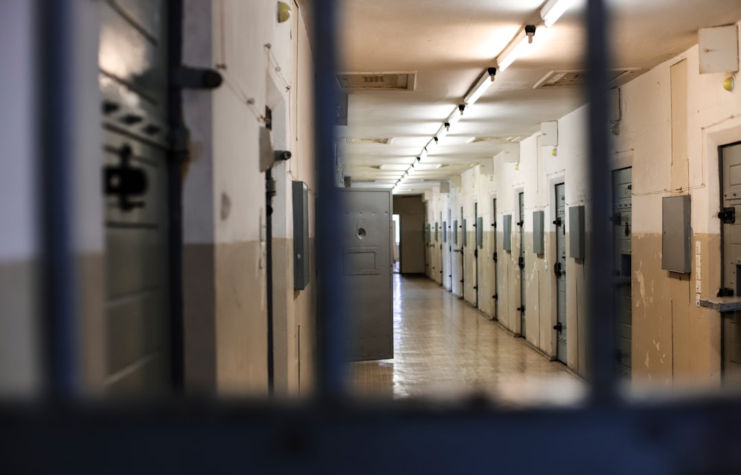 Corridoio di celle carcerarie con sbarre in primo piano, metafora di punizione e limiti all'educazione dopo la sentenza della Cassazione