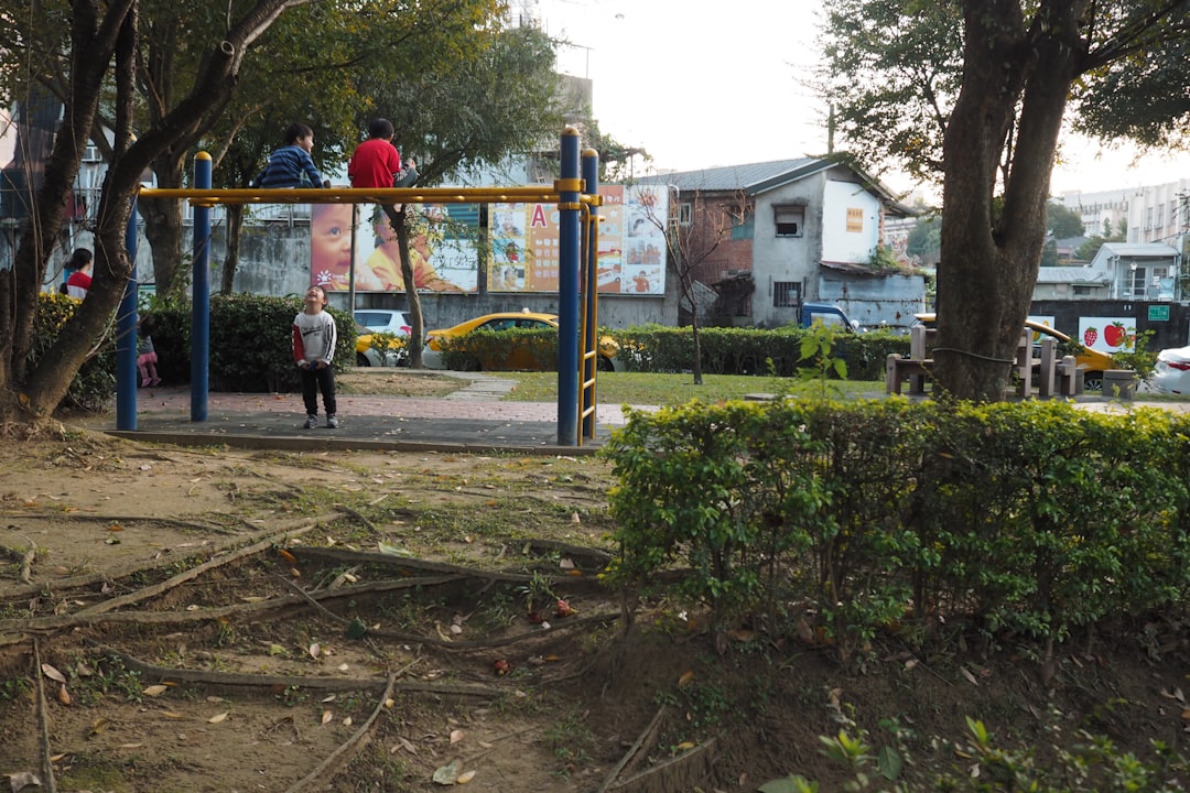 Bambini giocano in un parco giochi vicino a un asilo, contesto di sicurezza e intervento delle forze dell'ordine in zona.