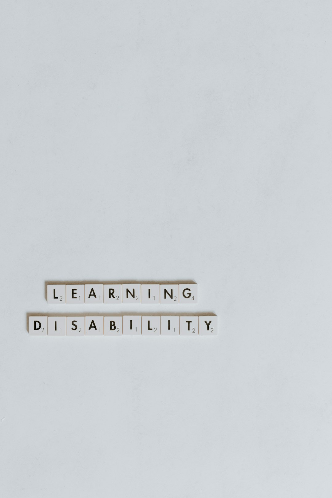 Lettere di Scrabble compongono le parole Learning Disability, simbolo di inclusione scolastica e supporto per studenti con disabilità.