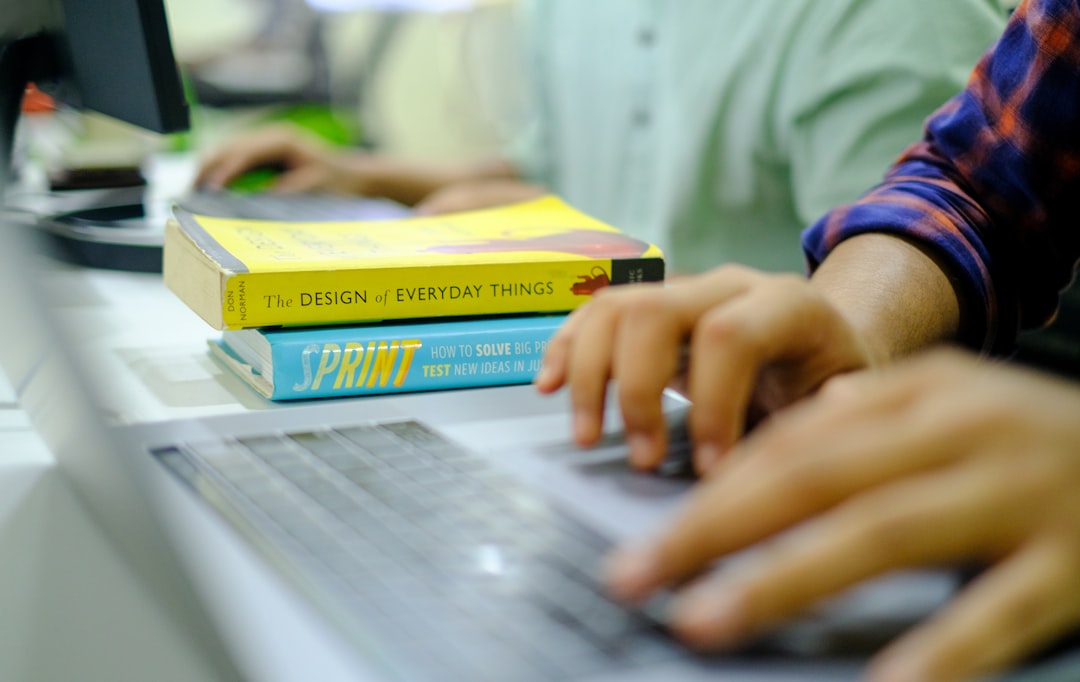 Studente al computer con libri sull'obbligo di istruzione e Anagrafe Nazionale Studenti (ANS) per caricamento dati