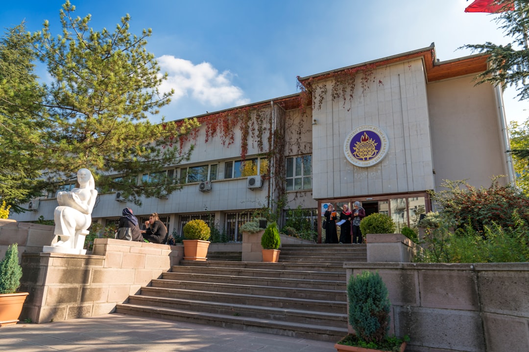 Edificio scolastico con persone e statua, focus sul rinnovo contratto scolastico e prossimi incontri Aran del 9 ottobre.