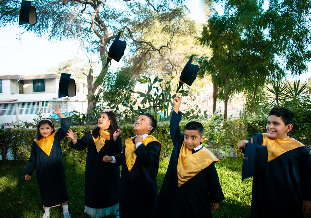 Bambini festeggiano la fine dell'anno scolastico con lancio del tocco, progetti AIRC nelle scuole contro il cancro, anno scolastico 2025/26.