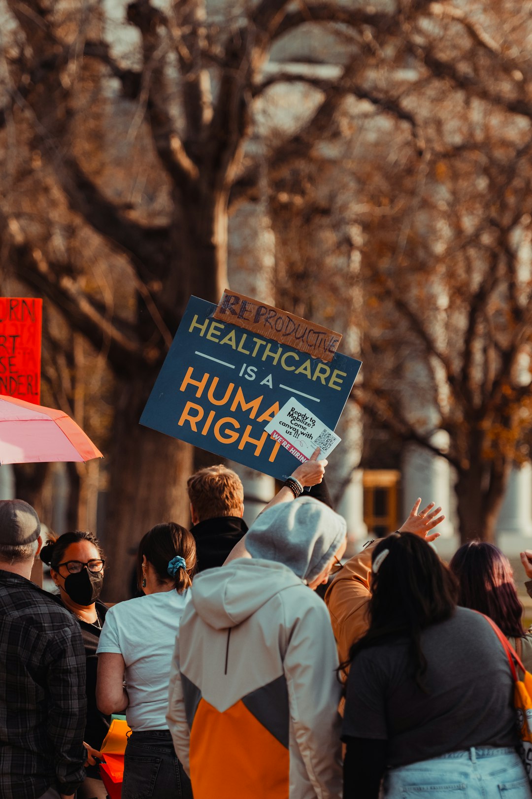 Manifestazione per la sanità pubblica: cartello con scritta Healthcare is a human right, importanza della prevenzione e DPI